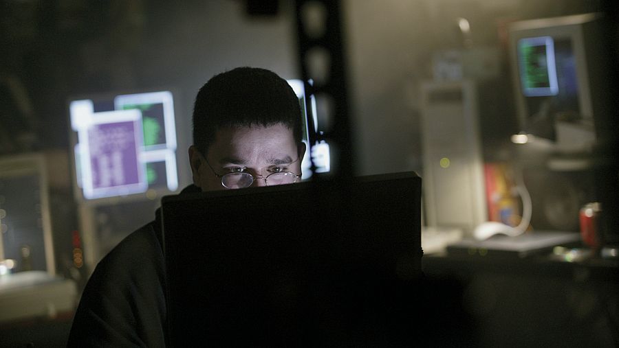 Informático trabajando con ordenadores en una habitación