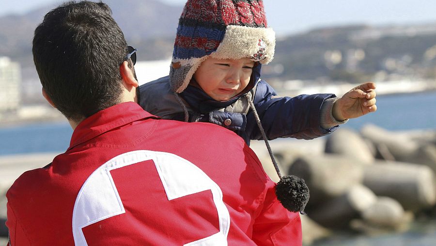 Voluntario de Cruz Roja ayudando a un niño
