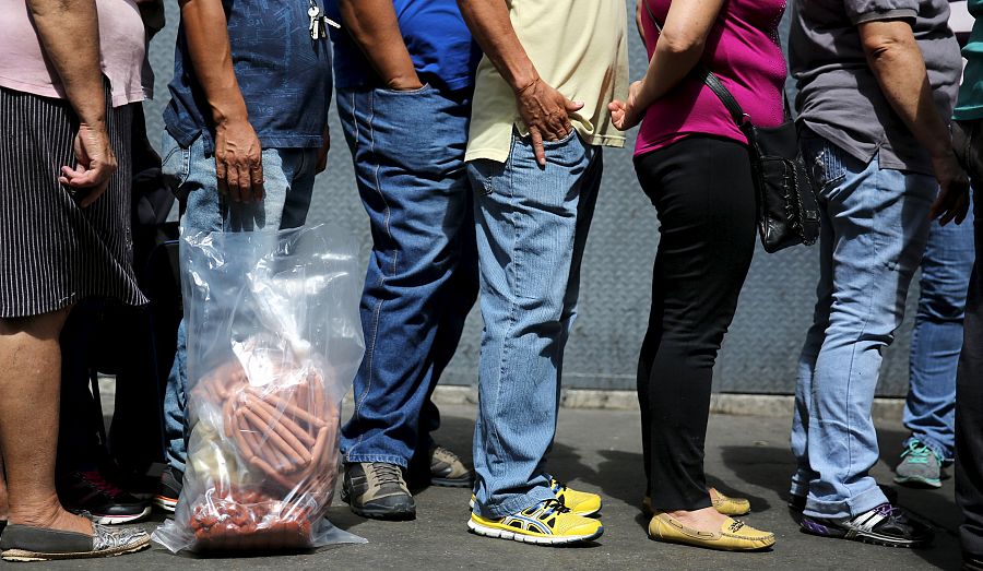 Los venezolanos hacen fila para poder comprar en una pollería de Caracas