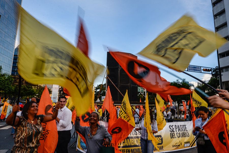 Varios opositores enarbolan banderas en el mitin de final de campaña de la Mesa de la Unidad Democrática en Caracas