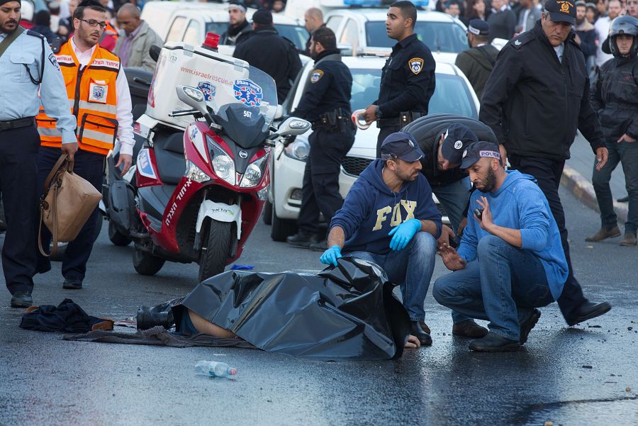 Dos agentes de la policía israelí examinan el cuerpo del palestino abatido en Jerusalén