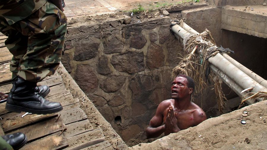 Un hombre suplica ayuda a un soldado tras huir de un linchamiento en Bujumbura, capital de Burundi,