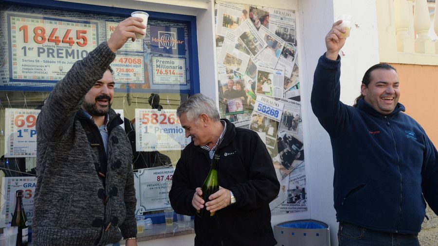 El propietario de la administración de lotería de Grañén junto a algunos premiados.