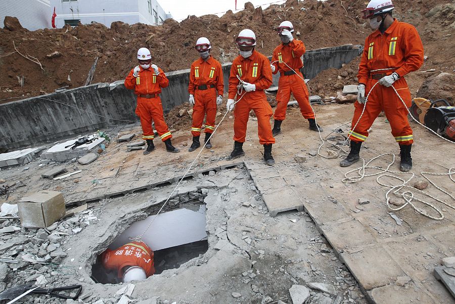 Miembros de los servicios de rescate entran en un edificio sepultado por los escombros en Shenzhen