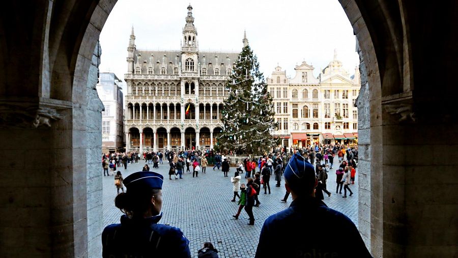 Dos policías vigilan la Grande Place de Bruselas, adornada con un abeto navideño