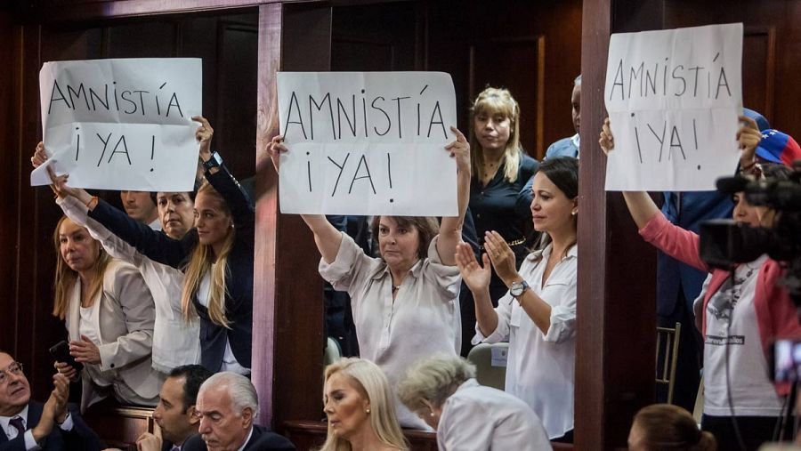 Lilian Tintori, Mitzi Capriles y Patricia Ceballos muestran carteles pidiendo una ley de amnistía durante la instalación de la Asamblea Nacional.
