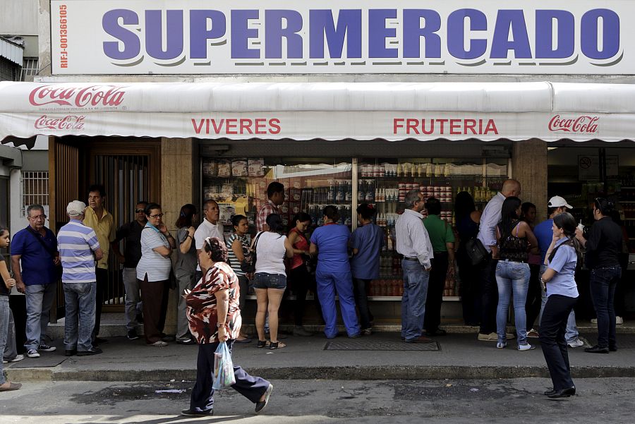 La gente hace cola en un supermercado de Caracas para adquirir productos básicos
