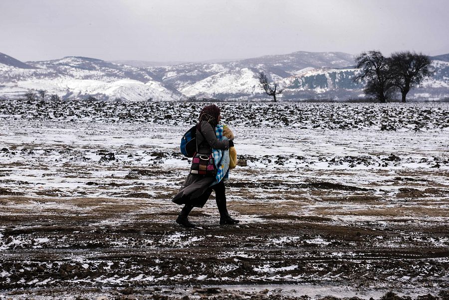 Una mujer refugiada cruza en mitad de la nieve la frontera entre Macedonia y Serbia.