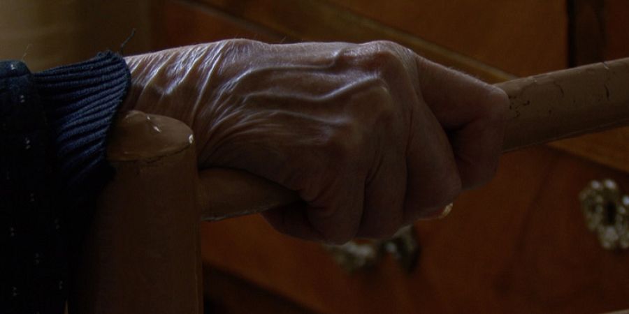 Detalle de la mano de Carmen agarrando la silla