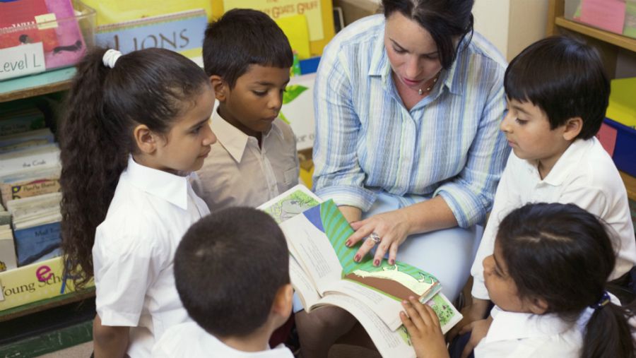 Profesora leyendo con sus alumnos
