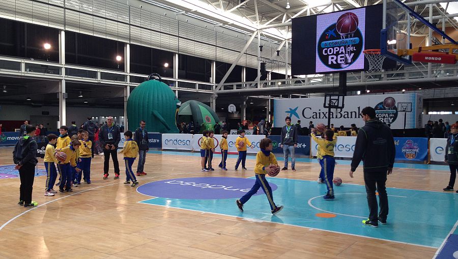 Un niño entra a canasta durante una de las clases de baloncesto impartidas.