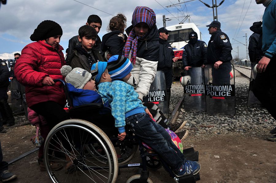 Un grupo de refugiados custodiados por la policía griega en Idomeni