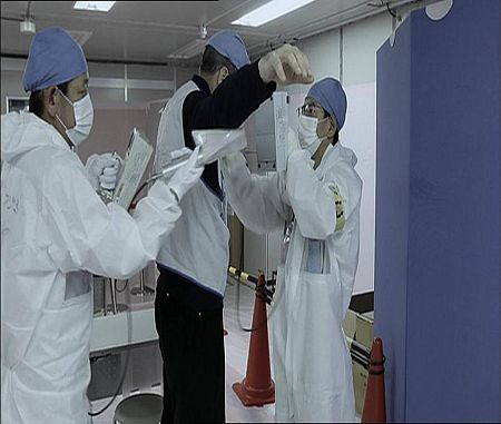 Trabajadores sometiéndose al escáner antes de acceder a las instalaciones