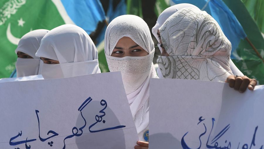 Partidarias de la formación islamista pakistaní Jamaa-e-Islami sujetan pancartas en Lahore por el día internacional de la mujer