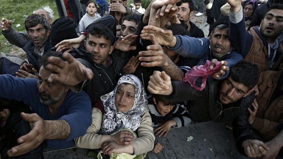Varios refugiados pelean por comida cerca de la localidad de Idomeni, en la frontera entre Grecia y Macedonia