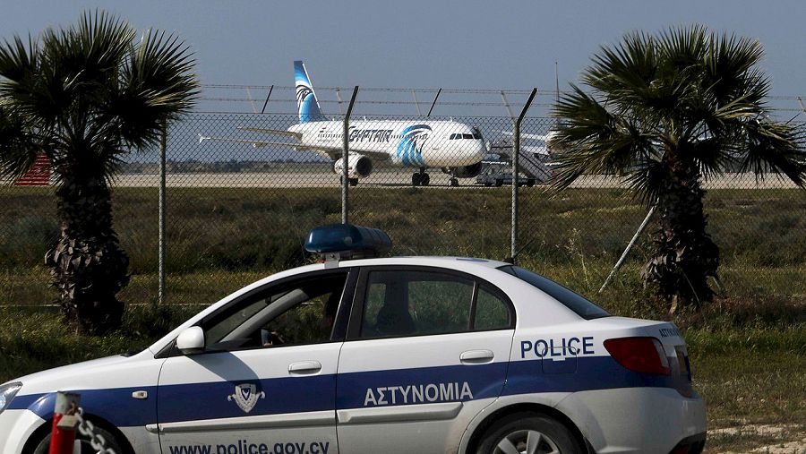 Policía en el aeropuerto de Larnaca, en Chipre. Al fondo, el avión de Egypt Air Airbus A320 secuestrado. REUTERS/Yiannis Kourtoglou