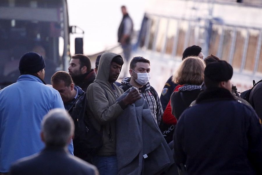 Varios inmigrantes deportados esperan para embarcar en Mitilene , el puerto de Lesbos, con destino a Turquía