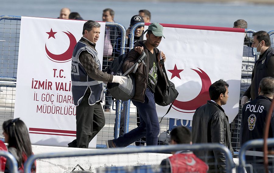 La policía escolta a los inmigrantes deportados que llegan al puerto de Dikili, en la provincia turca de Izmir, provenientes de la isla de Lesbos.