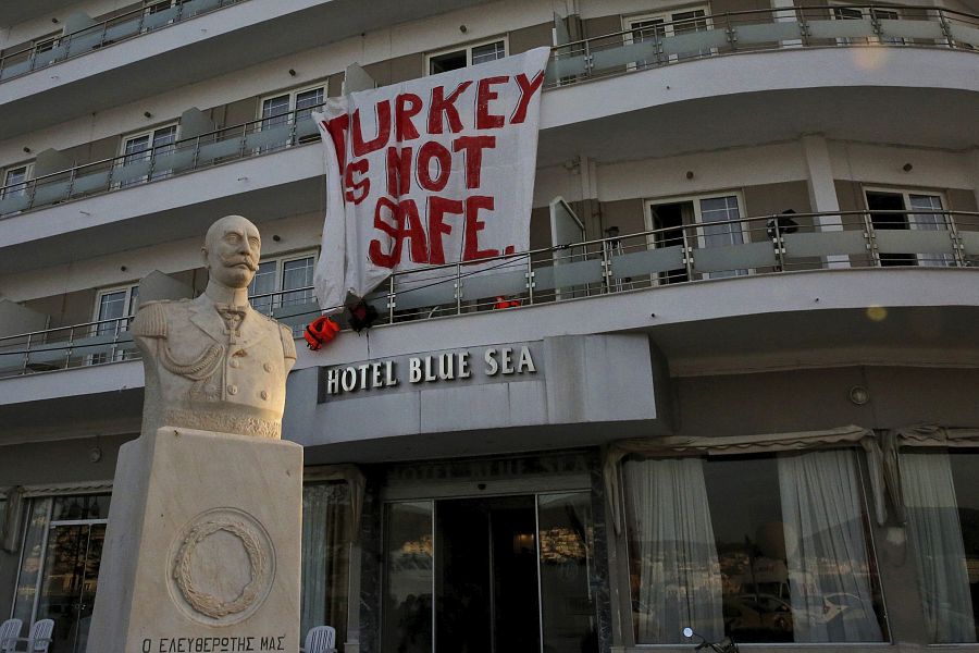 Pancarta colgada en la fachada de un hotel donde se alojan refugiados en el puerto de Mitilene, en la isla de Lesbos, en la que se puede leer: 