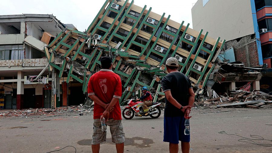 Dos hombres miran un edificio destrozado por el terremoto en Portoviejo, Ecuador