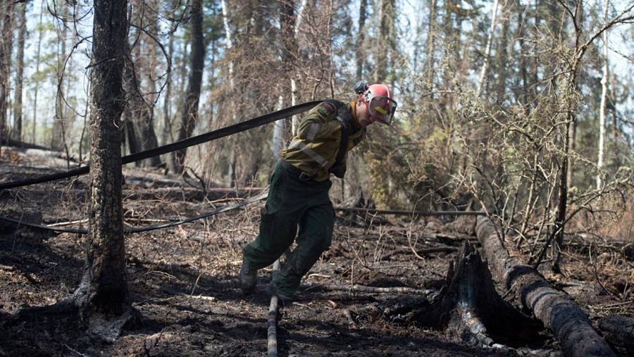 Un bombero lucha contra las llamas en la región de Fort McMurray