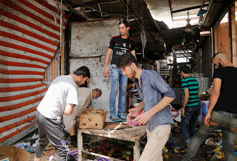 La gente se reúne para evaluar los daños del atentado en el mercado de Al Shaab, en Bagdad