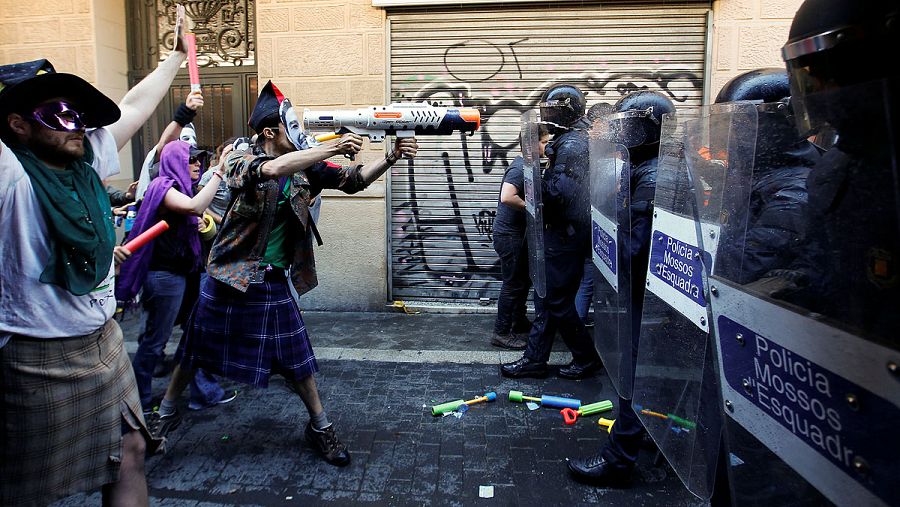 Manifestantes con la cara tapada increpan a los agentes que custodian el 'banco okupado'