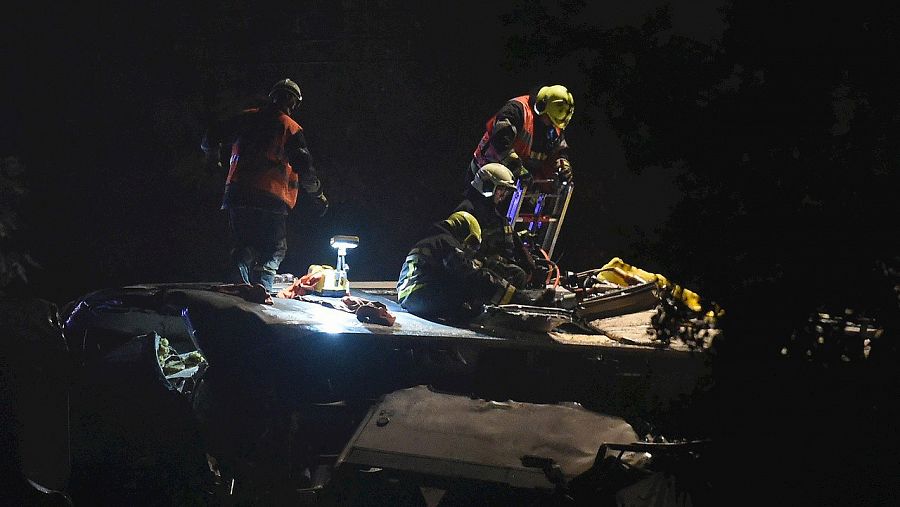 Equipos de rescate trabajan en el techo del tren de pasajeros que ha chocado con uno de mercancias en la línea entre Namur y Lieja, 5 de junio de 2016. AFP PHOTO / JOHN THYS