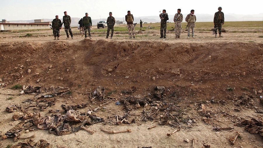Milicianos kurdos (peshmerga) ante una fosa común en los alrededores de Sinjar, en Irak. REUTERS/Ari Jalal