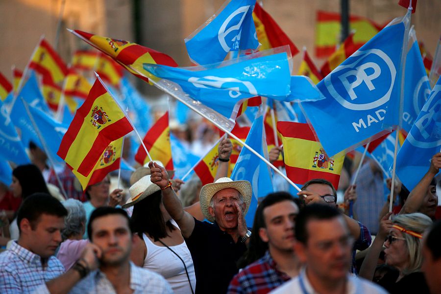 Simpatizantes del PP agitan banderas mientras aguardaban la llegada de Rajoy a la plaza de Colón.