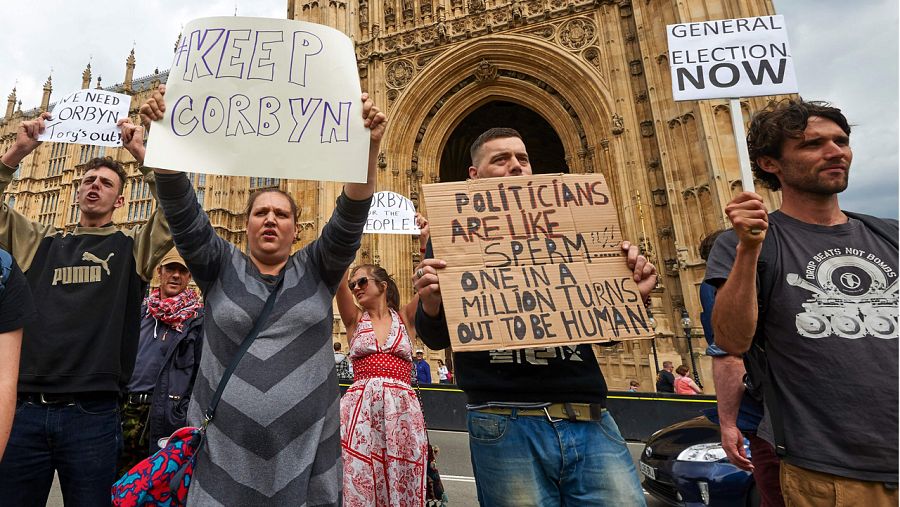 Manifestantes con pancartas protestan frente al Parlamento británico en Londres