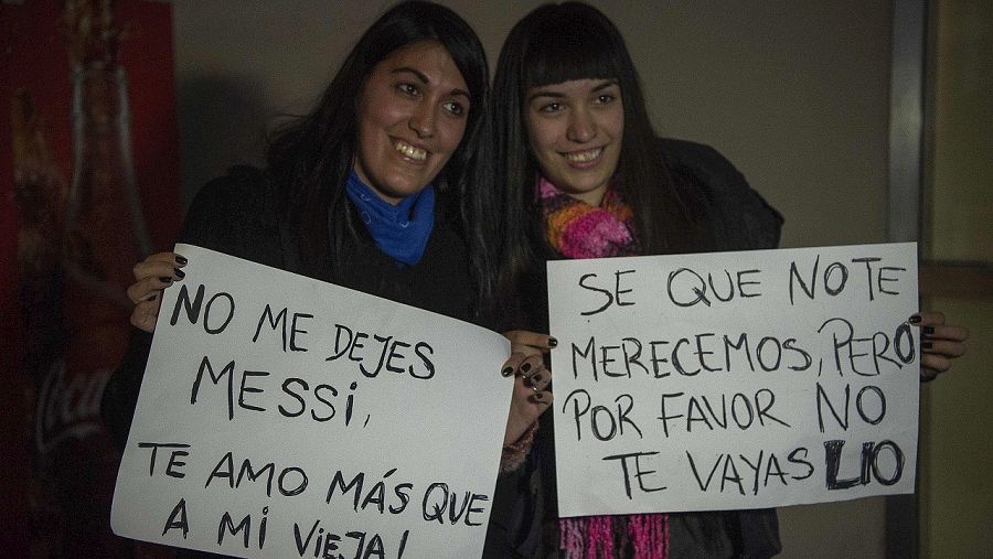 Dos aficionadas con carteles de apoyo a Messi en el aeropuerto de Buenos Aires. AFP PHOTO / EITAN ABRAMOVICH