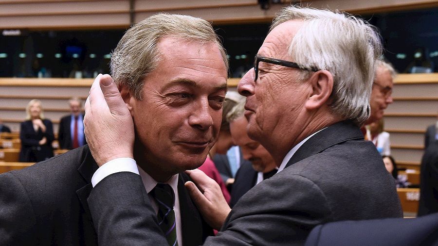 El presidente de la CE, Jean Claude Juncker, saluda a Nigel Farage, europarlamentario y líder del UKIP, en Bruselas. AFP PHOTO / JOHN THYS