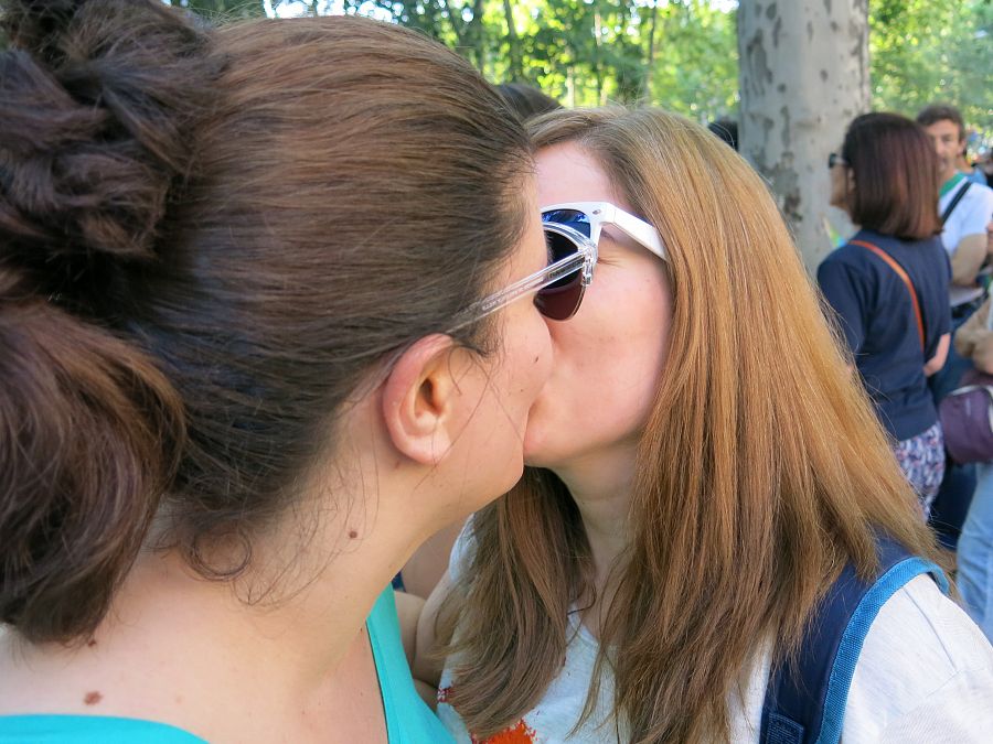 Una pareja de chicas se besa durante la marcha del Orgullo LGTB