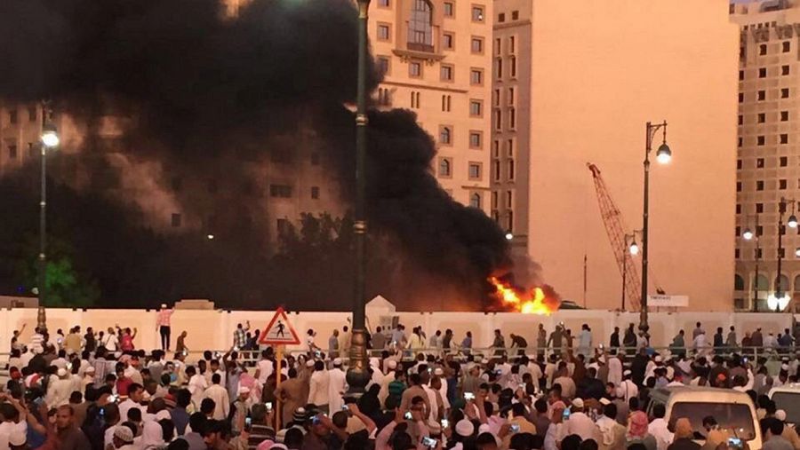 Musulmanes observan la humareda producida por una explosión en las proximidades de la Mezquita del Profeta en Medina