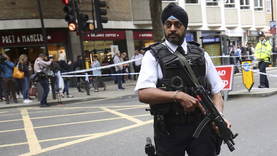 Un policía armado vigila el lugar donde 6 personas fueron apuñaladas este jueves en Londres