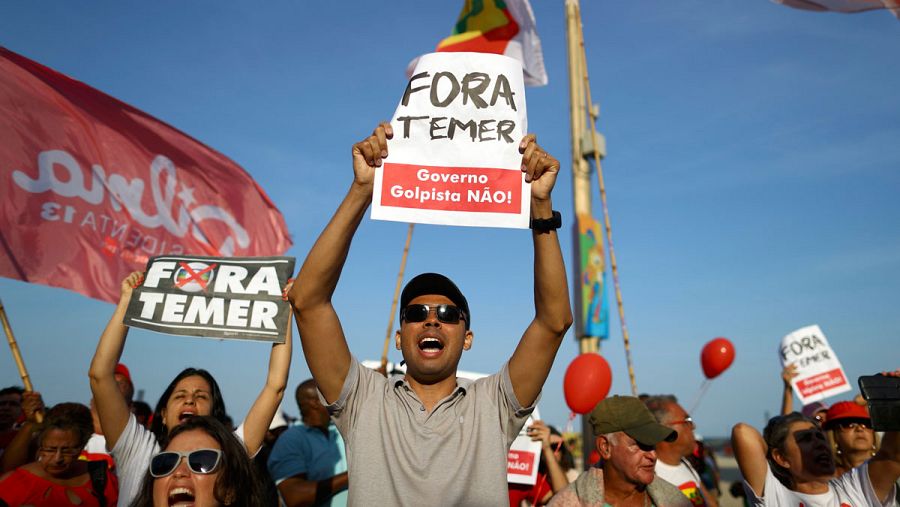 Manifestantes en Río de Janeiro, horas antes de la ceremonia de inauguración de los Juegos Olímpìcos el pasado viernes 5 de agosto, muestran carteles contra el presidente interino, Michel Temer.