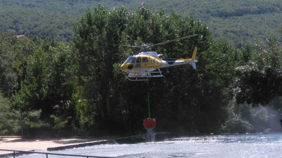 Un helicóptero coge agua de la Garganta de los Infiernos, en el Valle del Jerte (Cáceres)