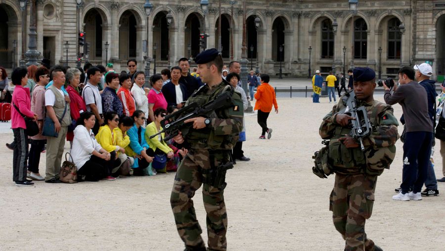 Soldados franceses patrullan en los alrededores del Museo del Louvre, en París, mientras un grupo de turistas chinos se toma una foto