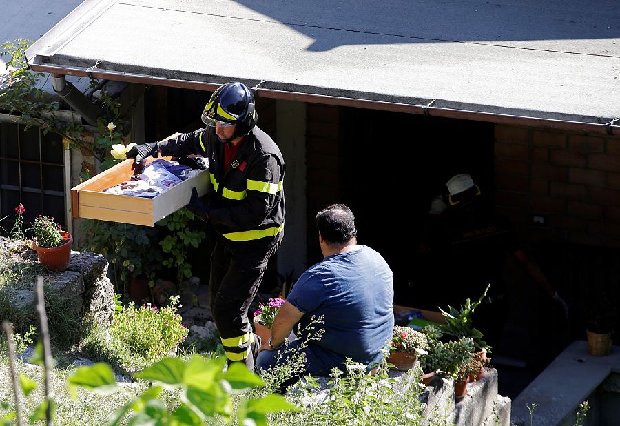 Un bombero recoger las pertenencias de la casa de un vecino en Pescara del Tronto.