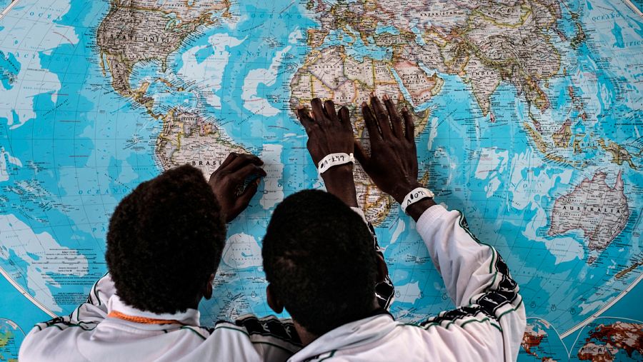 Dos niños refugiados de Gambia consultando un mapa el 17 de mayo 2016, en el Puerto de Pozzallo en Sicilia, Italia.