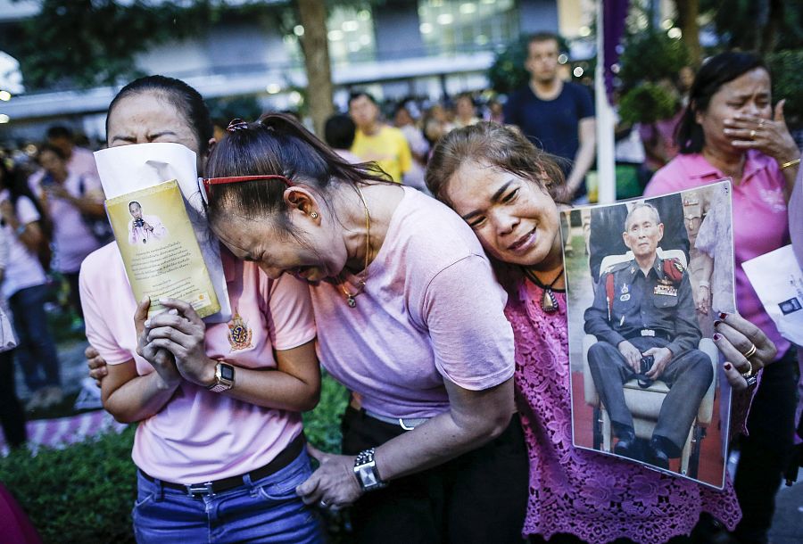 Dos mujeres tailandesas lloran tras conocer el fallecimiento del rey Bhumibol Adulyadej en Bangkok.