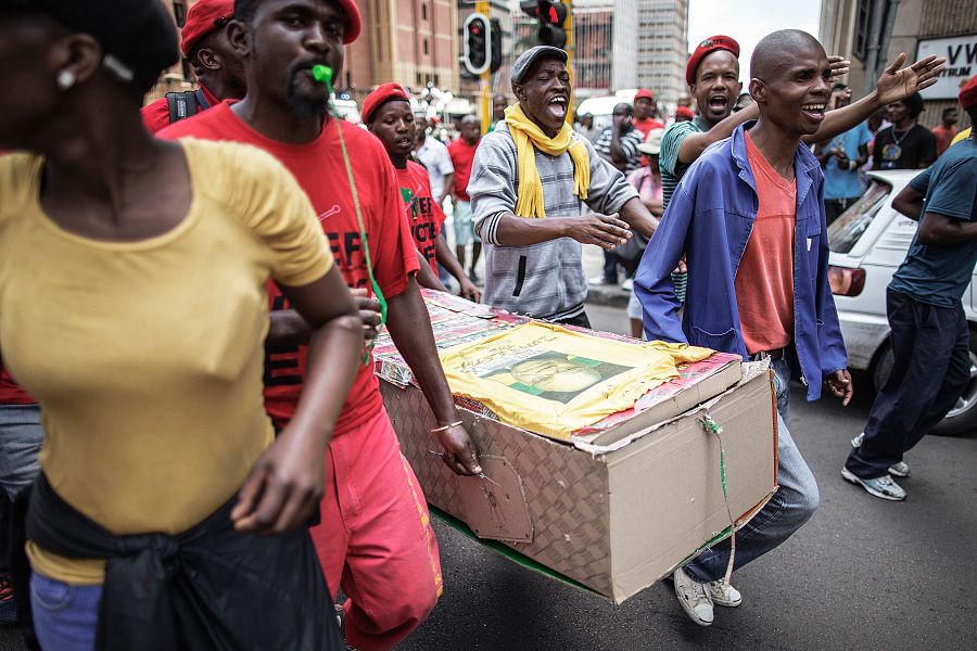 Varios manifestantes acarrean con un féretro con la imagen de Jacob Zuma en la protesta contra el presidente sudafricano celebrada en Pretoria