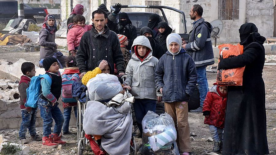 Familias sirias huyen del este de Alepo y esperan poder entrar en las zonas controladas por el gobierno sirio.