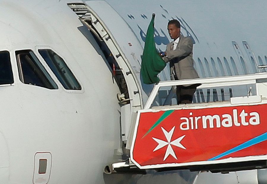 Uno de los secuestradores del avión libio enarbola una bandera verde fuera de la aeronave