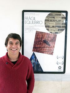 Guillermo García, director de 'Frágil Equilibrio', junto al cartel de su película en los Cines Renoir de Madrid.