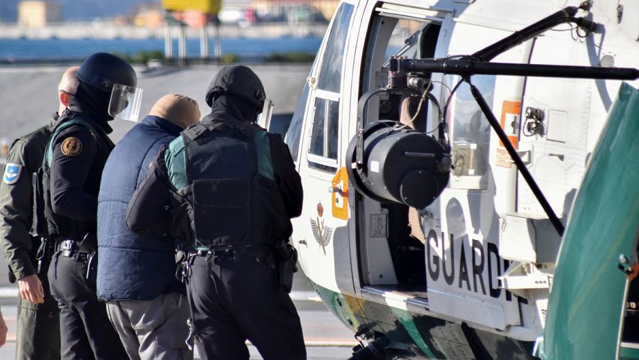 La Guardia Civil escolta a uno de los detenidos al helicóptero en el que será trasladado a Madrid