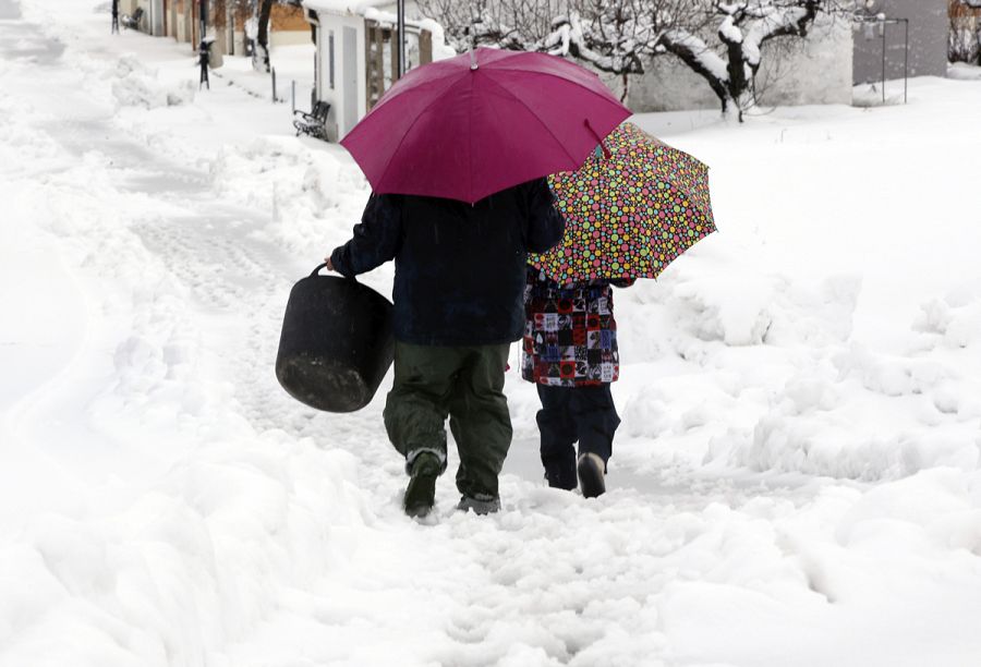 Dos vecinos de Famorca, en la Comunidad Valenciana, caminan entre una espesa capa de nieve