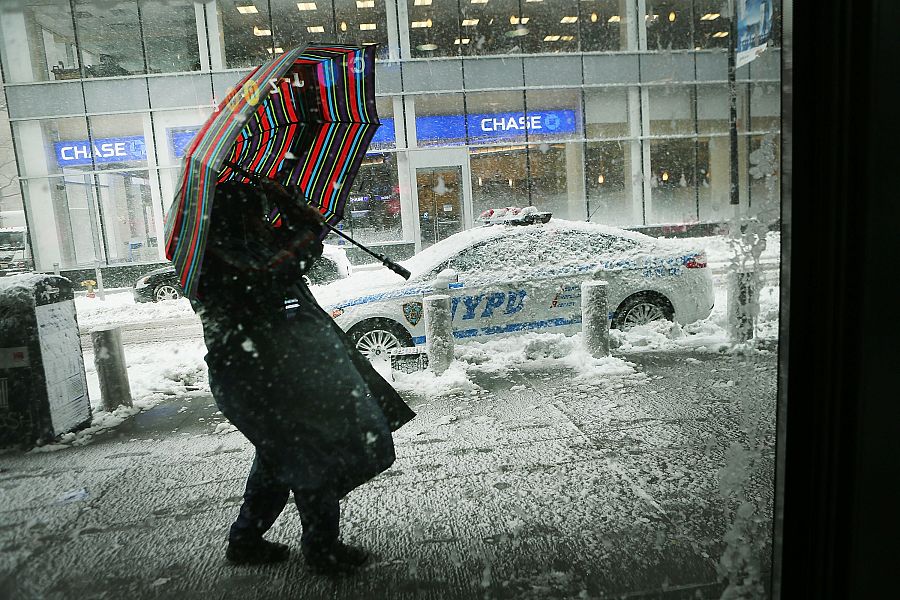 Una mujer trata de caminar entre la ventisca que azota la ciudad de Nueva York