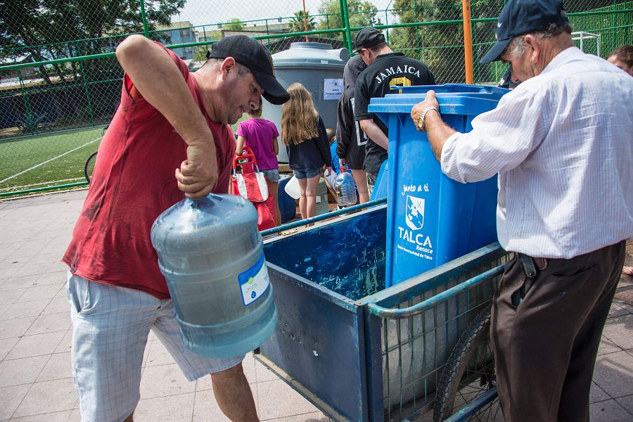 Afectados por los cortes de agua acuden a uno de los puntos de suministro habilitado por las autoridades.